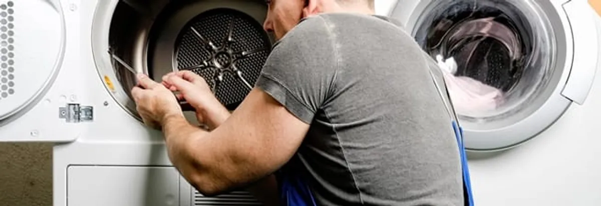 Dryer repair technician fixing a clothes dryer drum in Bellevue, WA