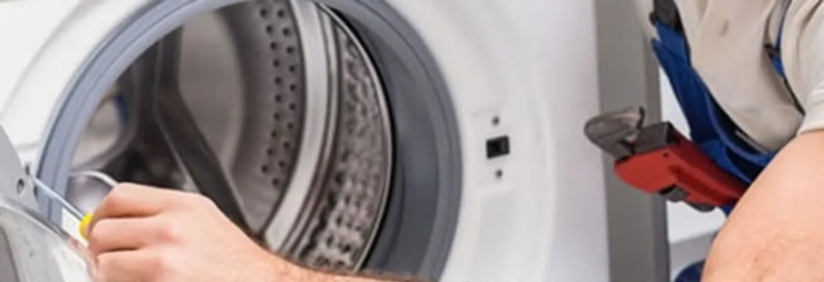 Appliance technician repairing a clothes dryer drum and internal parts in Bellevue, WA