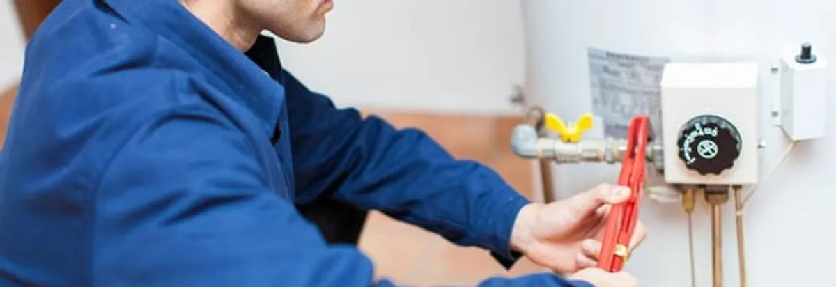 Water heater repair technician adjusting the temperature control and gas valve in Bellevue, WA